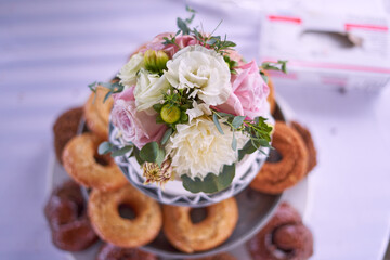 Flowers on top of cake with donuts