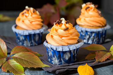 Pumpkin cupcakes. Autumn baking. Three muffins on a gray background. Close-up of a cupcake. Macro photography in food photography