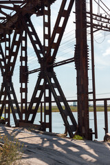 The metal structure of the old bridge across the strait . Old railway, road and pedestrian bridge.