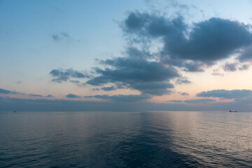 Fototapeta premium Evening cloudy skies over the calm blue sea. 
