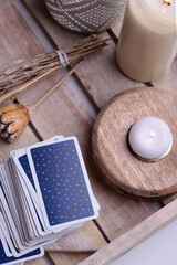 Fototapeta na wymiar Fortune teller concept background. Tarot cards close up on wooden tray on white background. Mystical and divination concept with candles.