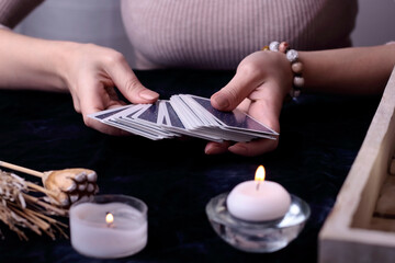 Tarot cards, fortune teller hands on a blue table background. Future reading concept. Divination. Selective focus of psychic tarot cards in woman hands.