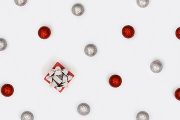Christmas baubles decorations, red and silver colored balls and gift box. New Year holiday pattern, minimal style