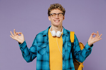 Young boy teen student in casual clothes backpack headphones glasses spread hands in yoga om gesture meditate isolated on pastel light violet background studio Education in university college concept.