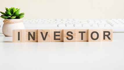 the word investor written on wood blocks with button. concept of approving in business or finance.