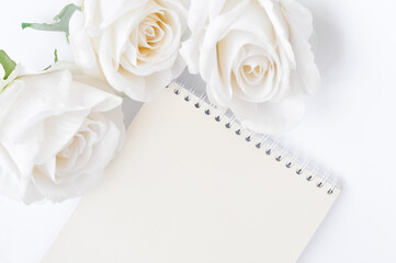 a book and white roses on the table, empty space for title