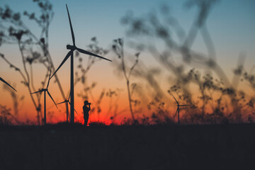 Silhouette Photographer taking photos of a Wind Turbines 