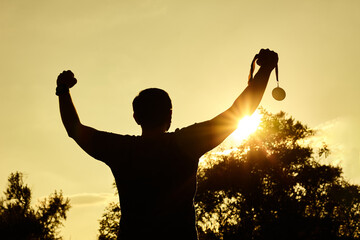 Silhouette people victory raising hands and holding gold medal with sunset sky. - obrazy, fototapety, plakaty