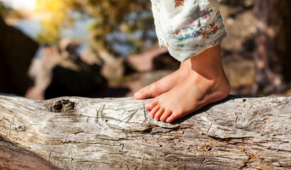 Barefoot feet on tree outside by the water. Close up of feet feeling nature and piece of wood....