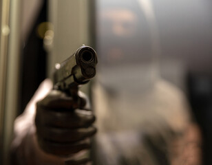 Gun barrel pistol metal weapon aiming everyone behind window. Killer with black balaclava.