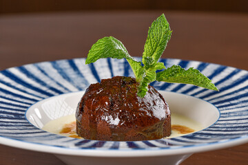 Sticky Toffee Pudding over Creme Anglaise topped with Caramel 