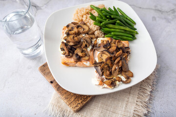 Salmon dinner with brown rice and green beans, topped with plain Greek yogurt and mushrooms.