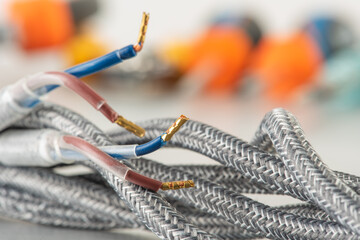 Braided fabric electrical cable close-up with terminals and blurred background