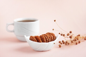 Cereal cookies with a cup of coffee on a pastel background. Close-up, selective focus.