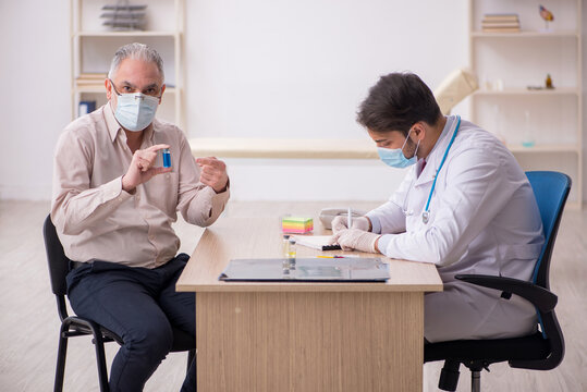 Old male patient visiting young male doctor in vaccination conce