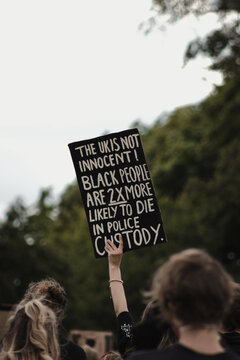 Banner with words " The UK is not innocent, Black people are 2X likely to be killed in police custody " held at protest