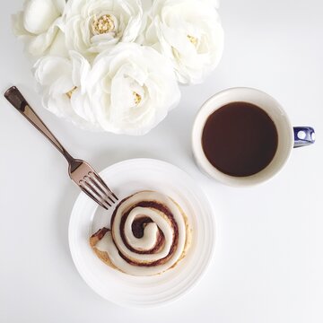 Cinnamon roll near coffee mug