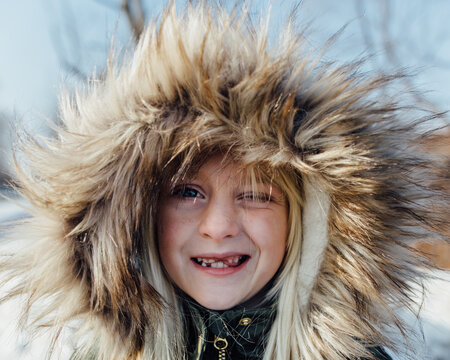 Close-up of young boy wearing beige fur coat