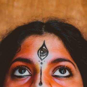 Close up shot of woman's with third eye tilak on forehead