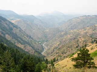 Fototapeta premium Cascades of mountains come together around a winding road below.