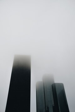 Four black skyscrapers in mist