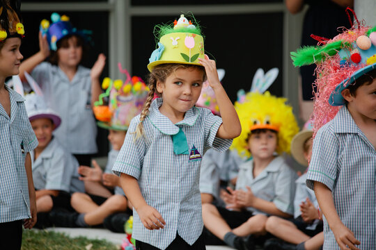 Girl in  checked button up shirt wearing yellow and green hat