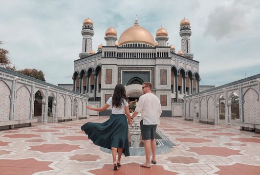 Man and woman walking towards Jame' Asr Hassanil Bolkiah Mosque