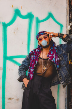 Man blowing bubble gum leaning on wall