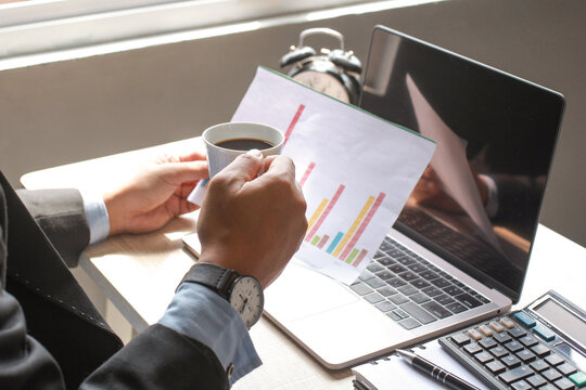 Man holding a cup of coffee and pivot table