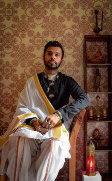 Man in black kurta sitting on chair indoor
