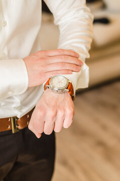 Man in dress shirt looking at his watch