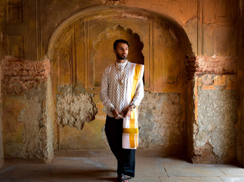 Man wearing traditional outfit and white textile standing in Safdarjung's Tomb