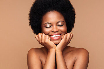 Beauty portrait of young african woman with perfect clean skin, curly afro hair, white toothy...