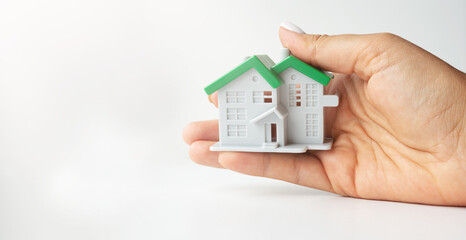 Figure of a toy house in an open palm on a white background. Property insurance concept