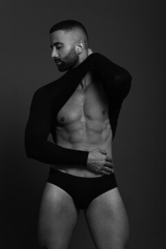 Monochrome photo of man in boxers showing off his six packs