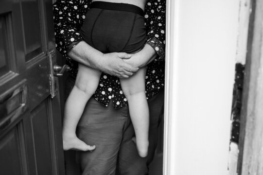 Mother holding son at front door