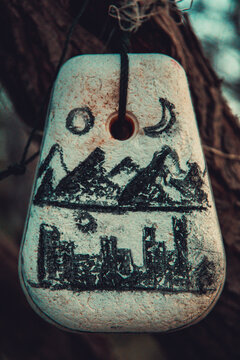 Mountain and building drawing on pendant