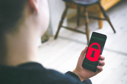 Person holding a smartphone showing padlock on screen - Powered by Adobe