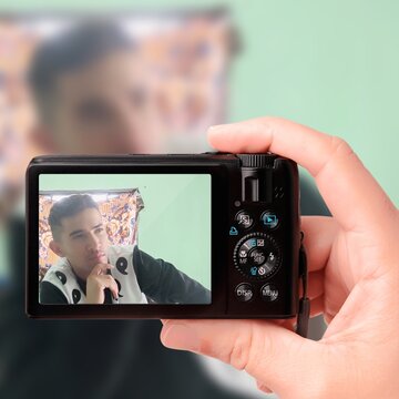 Person holding camera and taking a picture of man