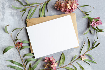 Wedding invitation or greeting card with copy space mockup with envelope and stylish flowers...