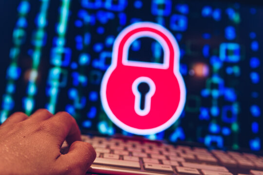 Person typing on a computer with padlock on screen