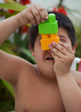 Portrait of  boy  with down syndrome holding blocks