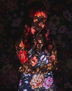 Portrait of a woman with screen projector projecting floral pattern on her