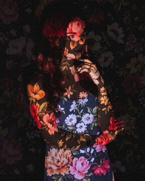 Portrait of a woman with screen projector projecting floral pattern on her