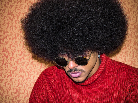 Portrait of man waring red turtleneck sweater with afro hair
