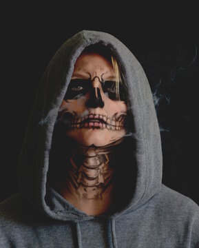 Portrait of Woman in Halloween themed painted mask and hoodie