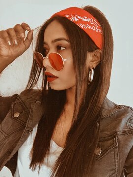 Portrait of woman with bandana and red sunglasses looking away