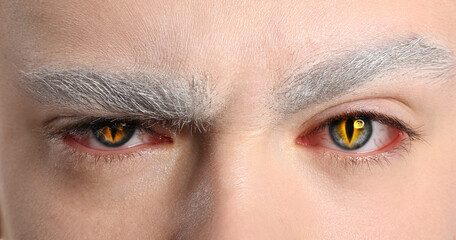 Young man wearing creative contact lenses for Halloween party, closeup