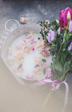Roses and rose petals in a bucket of milk