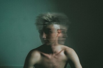 time-lapse of man moving his head beside blue wall